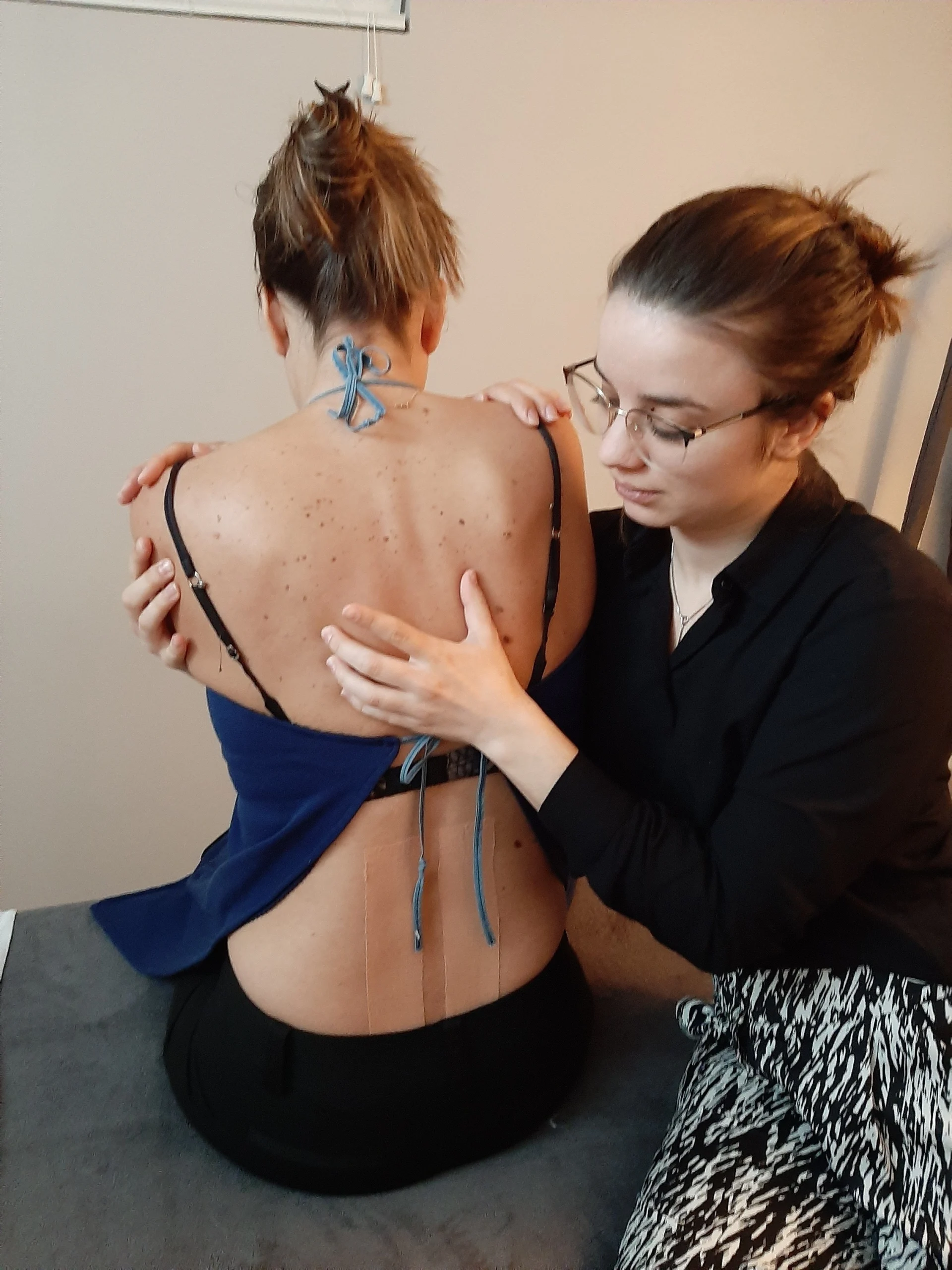 A woman analyzing a woman's back